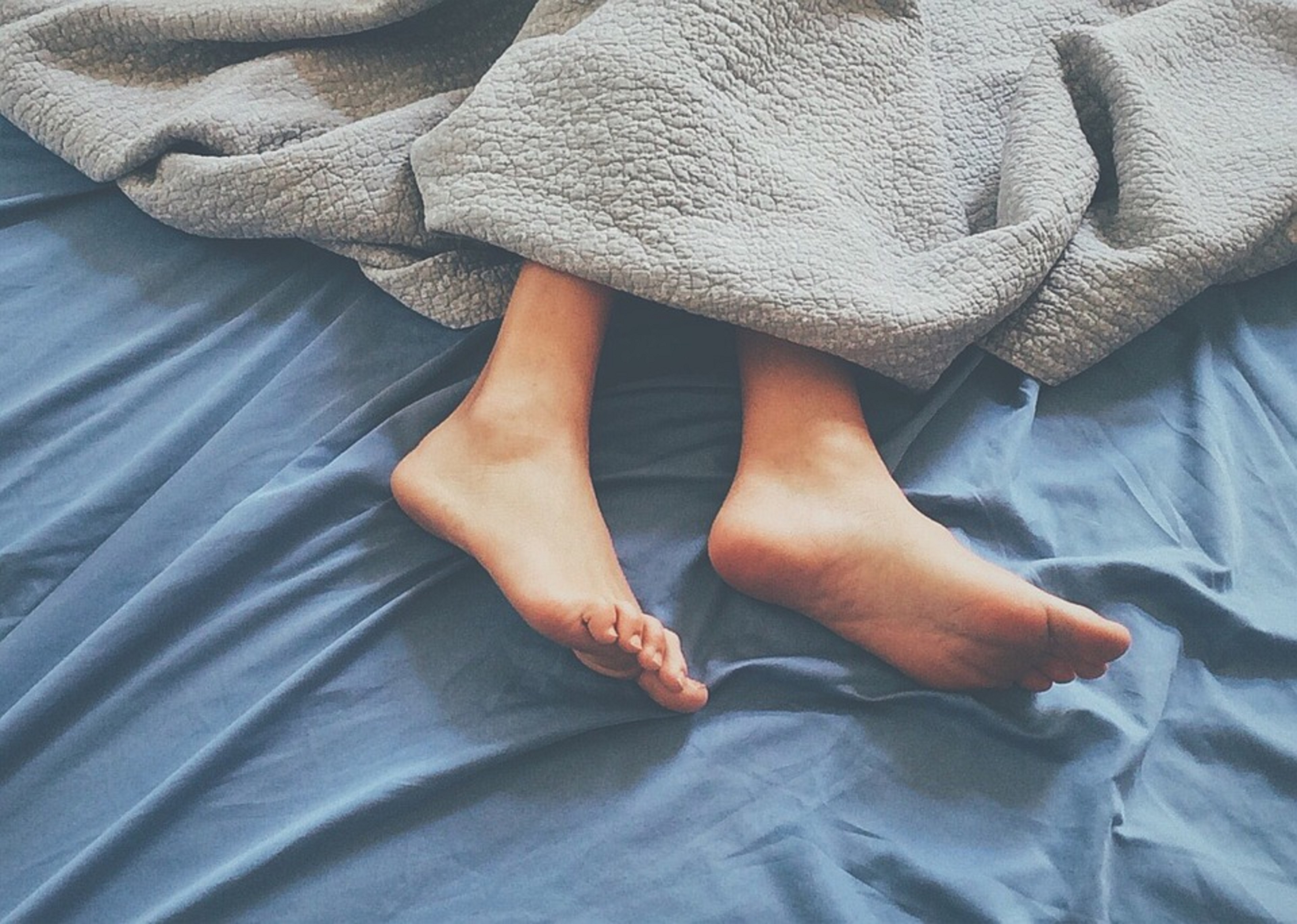 Спать поджав ноги. Ступни девушек. Ноги под одеялом. Стопы девушек. Ноги из под одеяла.
